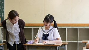 授業を受ける女子中学生と女性教師