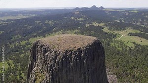 A drone shot of Devils Tower, a massive, monolithic, volcanic stout tower, or butte, located in the Black Hills region of Wyoming.