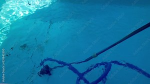 Vacuuming swimming pool floor debris with blue aluminum telescopic pole in 4K Stock Video