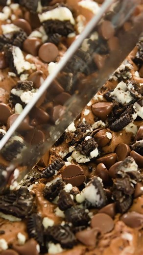 The Ultimate Slutty Brownies are made with our tried and true chocolate chip cookie dough, a layer of Oreo cookies, our famous brownie recipe, and then finished off with crumbled Oreo and chocolate chips for the ultimate over the top dessert! https://thestayathomechef.com/slutty-brownies/ | The Stay At Home Chef