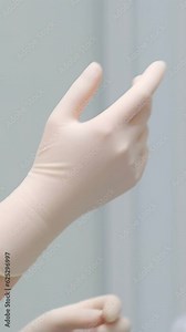 Individual protection products vinyl disposable gloves in spread of virus and protection against infections. Women is dressing hands in gloves nurse putting on washable surgical gloves to doctor
