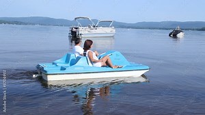 senior couple on pedalo also called pedal boat on a lake at daytime