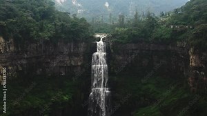 The Tequendama Falls cascade powerfully down a rocky cliff in Colombia, surrounded by lush greenery