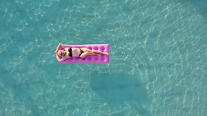 Young pretty woman with perfect body lying on air mattress