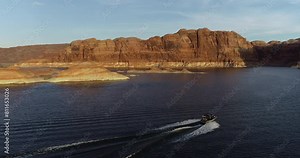 Beautiful sunset glow over lake Powell and motor boat - drone shot