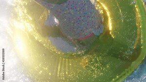 children swimming in pool with colorful swim tube inflatable toys splashing playfully having fun together on water floats enjoying summer vacation underwater view