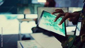 Military IT professional gathers intelligence from world map projection, tablet connected to satellite reconnaissance system to support field troops. Dispatch army command post. Close up. Camera B.