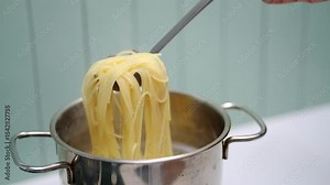 Boiling spaghetti noodles in a pot. Preparation of a classic pasta dish, commonly used in home cooking and popular Italian cuisine.