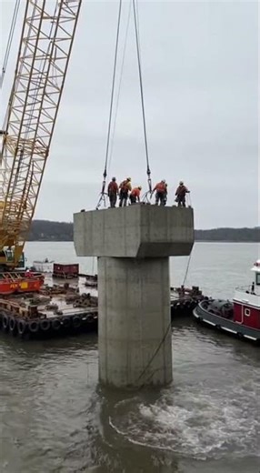 Workers stagger back as the structure slams into the water hard!