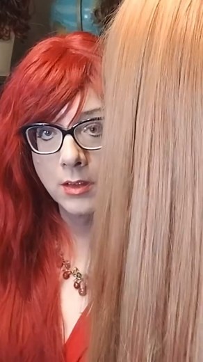 Inconstant Avatar on Instagram: "This is a clip from my Red Session. Wearing a bright red wig while brushing out a long wig of a lighter shade of red. Wearing also a red dress. This clip has no talking, like the long form video. #wigs #wig #genderfluid #genderqueer #hairplay"
