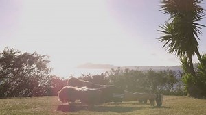Two Women Doing Push Ups in Front of the Ocean
