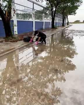 Unclogging a Street Drain During a Heavy Rainstorm