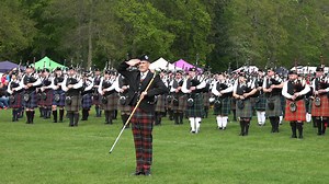 Drum Major Michael Leitch leads the massed Pipe Bands salute to the Chieftain, as they play "Highland Laddie" during the finale of The North of Scotland Pipe Band Championship - Banchory 2024. This was held at King George V Park in Banchory on Sunday 12th May 2024. The Chieftain is Donald Farquharson, 16th Laid of Finzean, who gives the speech here. There was a great turnout of Pipe Bands taking part in this championship, thanks to the efforts of the organisers Banchory District Initiative, in c