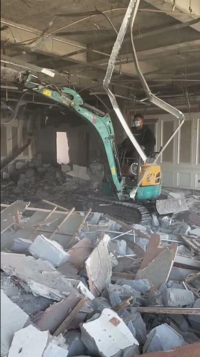 Small excavator vibratory hammer demolishes indoor walls more efficiently than manpower