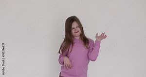 Capricious little girl waves hands expressing unwillingness on white. Kid with active facial expression playfully demonstrates emotions