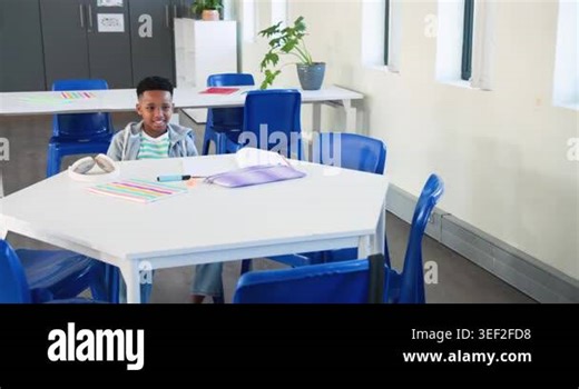 African American preteen smiling and raising hand to answer question in class at table with headset. Student, classroom, education, learning, notebook, headphones, hexagonal Stock Video Footage - Alamy
