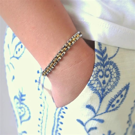 PRODUCT DETAILS Waterproof💧💧💧 Stainless Steel White Rhodium 18K Gold and Silver Hypoallergenic Nickel Free SIZE: 6mm width, Adjustable – Total 7.5” – (6.5” 2” extender) CLOSURE: Clip Clasp Designer Note: Get ready for two-tone magic! Inspired by the overwhelming love for our regular-sized watch band, we had to create this daintier version. Perfectly combining gold and silver for a chic, modern look that will elevate any watch. Waterproof and crafted from 18K gold-plated stainless steel and ad