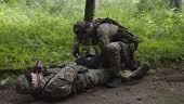 Combat medic taking first aid kit, providing emergency medical...
