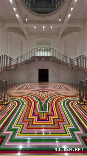 Scottish artist Jim Lambie is internationally recognised for transforming everyday spaces into vibrant optical experiences. Known for his use of colour, pattern and rhythm, Lambie draws from pop culture, music and minimalism to create installations that are both playful and exciting. His work often explores how simple materials can completely alter our perception of architecture and movement. His latest installation, Zobop (Colour Chrome), currently on view at the Vancouver Art Gallery until Oct