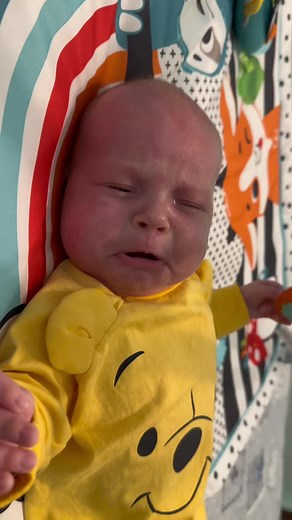 Adorable Baby in Bright Yellow Onesie Playing on Cushion