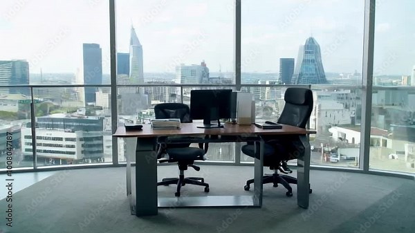 A modern office space with a desk and chairs overlooking a city skyline, reflecting a professional atmosphere.