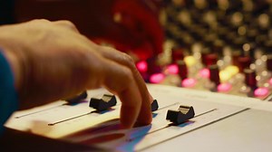 Audio expert recording and editing tracks with mixing console, twisting mixer knobs and changing settings. Sound engineer working in control room to produce music, key buttons. Close up. Camera A.
