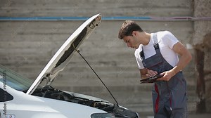 Car service, computer diagnostics: mechanic looks for errors in the car