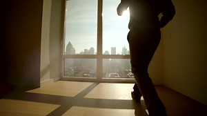 Young Successful Man Living in High Rise City Apartment With Skyline View