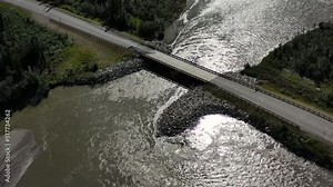 Small bridge on Portage Glacier road over mountain river rapids in Portage valley, Alaska USA - aerial