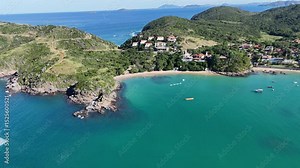 Imagem aérea de drone da Praia da Ferradura, em Armação dos Búzios, Rio de Janeiro, Brasil. Uma enseada de águas calmas, cercada por vegetação e casas de alto padrão, ideal para turismo e esportes náu