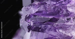 Amethyst crystals macro footage detail texture background. close-up raw rough unpolished semi-precious gemstone