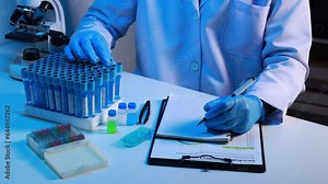 Lab assistant, a medical scientist, a chemistry researcher holds a glass tube through the blood sample, does a chemical experiment and examines a patient's blood sample. Medicine and research concept.