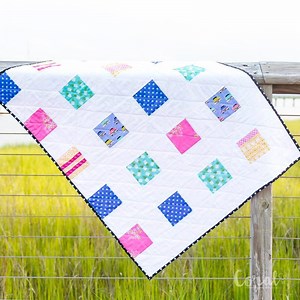 Make an easy baby quilt! The Free Four Square Quilt Pattern is super fast to sew. Finish the entire quilt in only 4 hours. And it's even scrap friendly. Find the full pattern here: https://www.coralandco.com/simple-charm-pack-baby-quilt.html | Coral & Co.