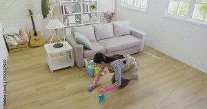 slow motion of young girl house maid cleaning wooden floor with detergent and blue cloth. asian lady protect hands with rubber gloves from cleaner. beautiful housewife doing spring house clean work.
