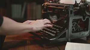 Woman typing on typewriter, slow pull out as woman types on vintage underwood typewriter | Premium Stock Video Footage