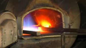 Blacksmith furnace, forge from which the tongues of flame. with metal bar. Homemade furnace with gas flame.