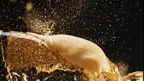 Beer bottle exploding with liquid and foam in a dynamic splash.