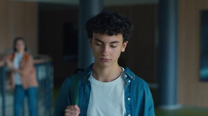 Caucasian male man guy pupil student schoolboy teenager walking going in corridor hallway in university college school sad upset bullying classmate boy pushing shoulder push bully violence problem