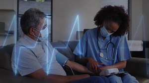 Premium stock video - Animation of cardiogram over diverse doctor and patient measuring blood pressure