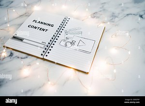 planning content for social media conceptual image, notebook with photo and video icon next to text and progress bar loading surrounded by fairy light Stock Photo - Alamy