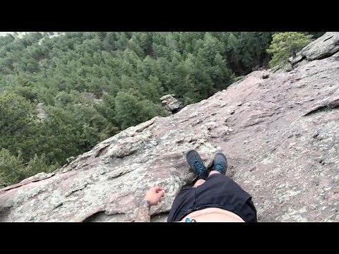 Man Stands On Ledge Of Huge Cliff Face