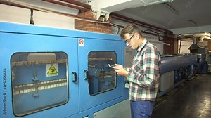 Engineer programs a machine for the production of propylene pipes 4k.