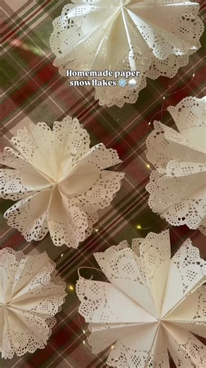 Devon Willo on Instagram: "Send this to someone who wants to have a crafty Christmas 🥰🎄 How to: Using paper doilies (I bought a variety pack on Amazon) fold 6 as shown in the video Use glue to glue the bottom halves of the inner folds together to create pocket After completing 6, glue them all together gluing along the bottom and across the center to create a T Fan all pieces out and glue the last piece to the first one I used string and tape to tape to the ceiling!"