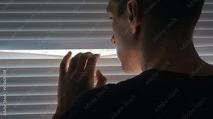 Paranoid man, Spy, journalist or detective, watches through the blinds