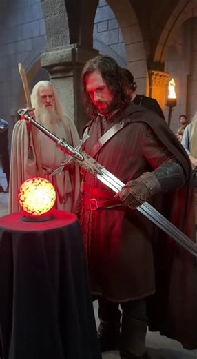 Aragorn Confronts Sauron Through the Palantír — Behind the Fiery Clash of Wills Step behind the shadow-drenched throne room as Aragorn grips the Palantír, facing Sauron’s overwhelming presence in a battle of sheer will. Deep red lighting rigs, swirling smoke effects, wind blasts, and reflective prop surfaces built the sinister atmosphere around this moment. Yeh BTS glimpse reveal karta hai kaise Viggo Mortensen ne fierce expressions, controlled body tension, aur raw emotional intensity ke saath 