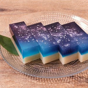 『夜空のような白桃ようかん』 【材料】 1台分(12cm×7cm×4.5cm寒天流) ----- 桃ようかん ----- 白あん 150g 白桃（缶詰） 50g シロップ（缶詰のもの） 50ml 粉寒天 2g ----- 寒天液 ----- 水 150ml 粉寒天 3g 上白糖 30g アラザン 小さじ1/4 ----- 色付け用 ----- 水（紫用） 小さじ1 食紅（赤） 適量 水（青色用） 小さじ1 食紅（青） 適量 【手順】 型は水で濡らしておきます。 1. 白桃は、1cm角の角切りにします。 2. 水と食紅を混ぜ、青と紫の色水を作ります。 3. 鍋に、寒天液の材料のアラザン以外を入れ混ぜながら中火にかけ、寒天が溶けたら沸騰状態を1分以上続けて火を止めます。 4. 型に移し、アラザンを入れて混ぜ少し溶かし、2を入れてそれぞれの色がグラデーションになるように混ぜ、冷蔵庫で30分冷やします。 5. ようかんを作ります。鍋に、シロップと粉寒天を入れ中火にかけます。粉寒天が溶けたら沸騰状態を1分以上続け、弱火にします。 6. 白あんを加え弱火のまま混ぜながら煮詰めます。鍋底が見える程度
