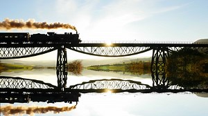 Historical steam engine train locomotive crossing railroad tracks