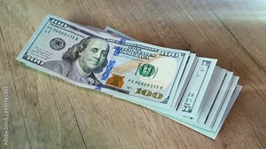 American 100 dollar bills banknote fall on the table. A big stack of money is dropped. Concept of finance and money payment.