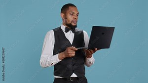 Bellboy doorman talks to guests on videocall connection before booking, explaining all five star resort amenities. Hotel concierge personnel discusses with clients on online conference. Camera B.