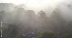 Aerial view over unrecognizable house in a spooky setting in Dense fog and woodland, Shot at Dering woods, Kent, UK